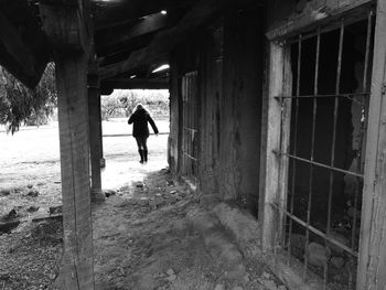 Rear view of man walking in corridor of building