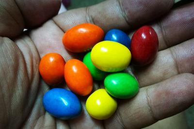 Close-up of hand holding multi colored eggs