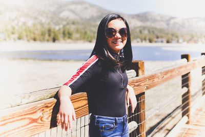 Portrait of smiling girl standing against lake