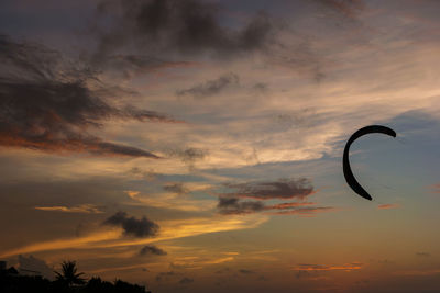 Low angle view of silhouette kite against sky during sunset