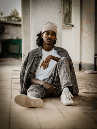 Portrait of young man sitting on floor