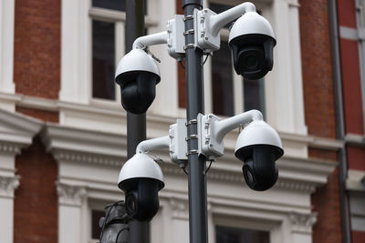 Low angle view of lighting equipment on street against building