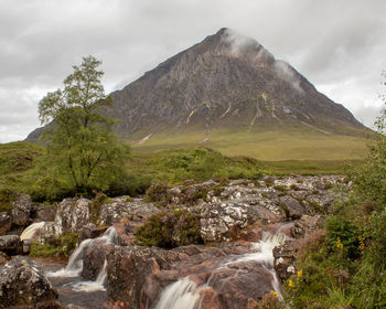 Scenic view of waterfall against sky