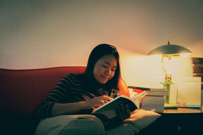 Young woman reading book at home