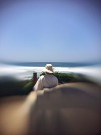 Rear view of woman standing by sea