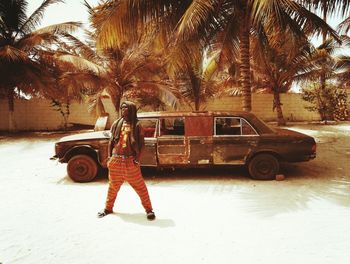 Full length of woman standing by car