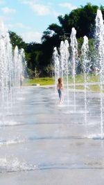 Full length of man splashing water fountain