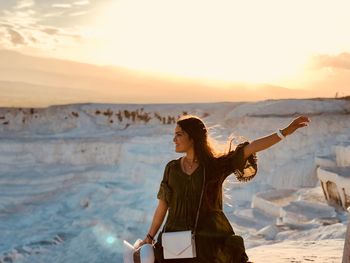 Smiling young woman gesturing while standing at pamukkale
