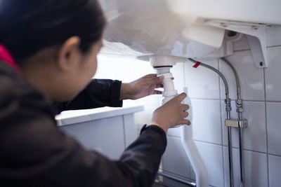 Woman fixing bathroom sink