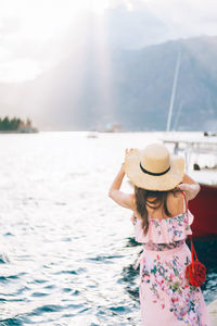 Woman with hat on sea against sky