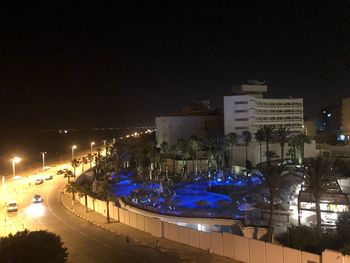 High angle view of illuminated street amidst buildings at night