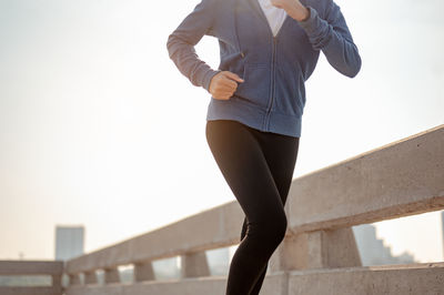 Low angle view of woman standing against clear sky