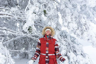 Portrait of woman standing on snow covered field