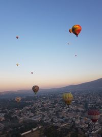 Hot air balloons flying over landscape against sky