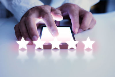 Close-up of hand holding candles on table