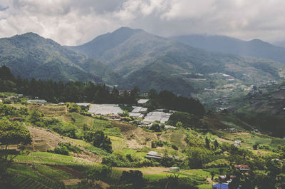 Scenic view of townscape by mountains against sky