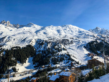 High angle view of snowcapped mountains against blue sky