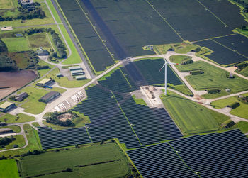 High angle view of solar panels and wind turbine on field