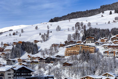 Snow covered houses and buildings against sky