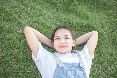 Portrait of smiling young woman lying on grass