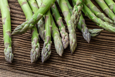 Raw garden asparagus stems. fresh green spring vegetables on wooden background. 