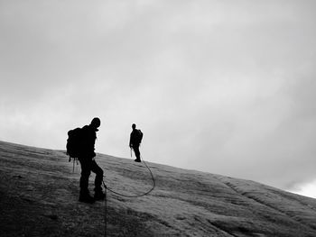 Full length of hikers on mountain against sky