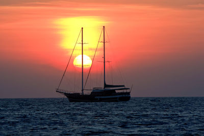 Ship sailing on sea during sunset