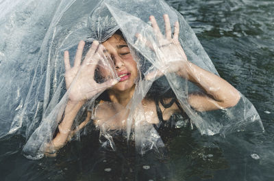 High angle view of girl amidst plastic in sea