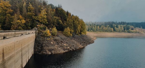 Scenic view of river in forest against sky during autumn