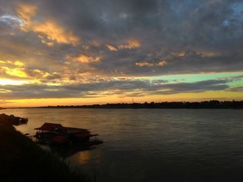 Scenic view of sea against cloudy sky at sunset