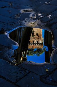 High angle view of building reflection in puddle