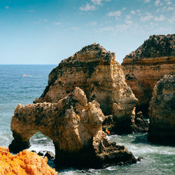 Rock formation on sea against sky