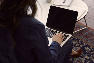 Mid section of woman using laptop