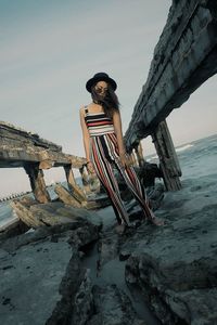 Low angle view of woman standing on beach against sky