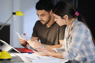 Young couple using laptop on table