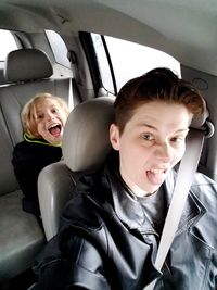 Portrait of playful mother and son traveling in car