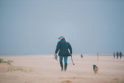 Rear view of man walking on beach