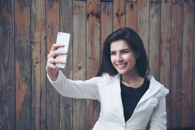 Portrait of smiling young woman using mobile phone