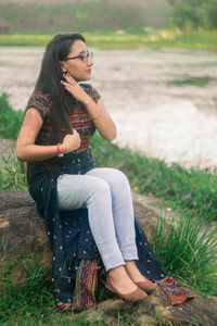 Young woman sitting on field