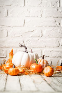 Close-up of pumpkins on table against wall