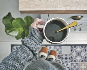 Cropped hand of person holding coffee on table