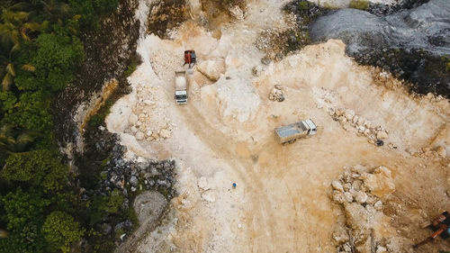 Aerial view wheel loader excavator machine loading dumper truck at quarry. 