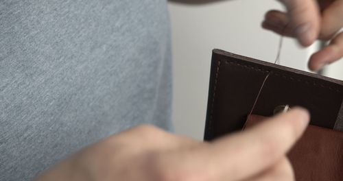 Midsection of man using mobile phone