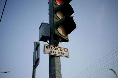 Low angle view of road sign against sky