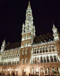 Low angle view of clock tower at night