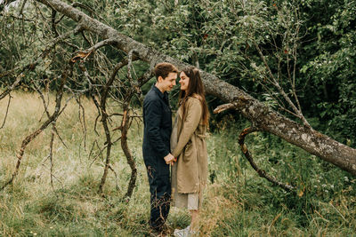 Woman standing by tree in forest