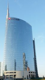 Low angle view of skyscrapers against blue sky