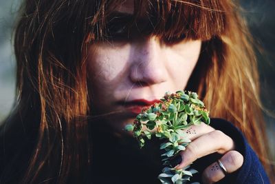 Close-up of woman smelling flowers