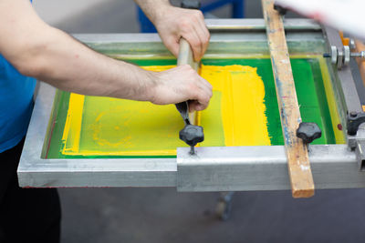 Midsection of person working on yellow grill