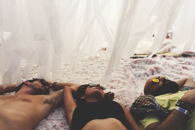 High angle view of friends sleeping on rug